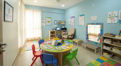 Pediatric speech and communication therapy clinic room at Mom's Belief Electronic City Bengaluru with bright interactive play tables, mirrors, and child-safe ergonomic furniture.